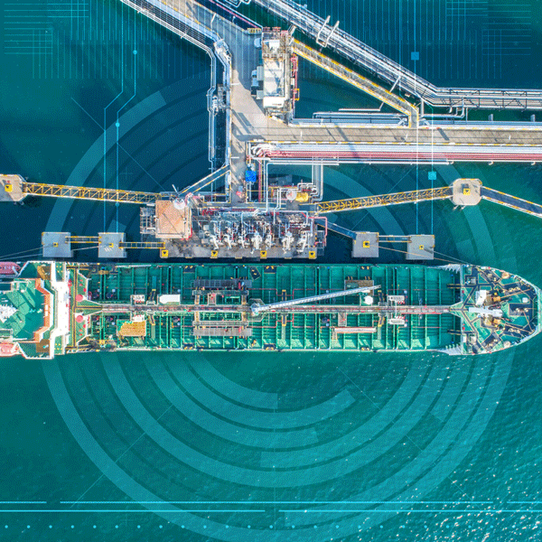 A ship at port with cranes hanging from above